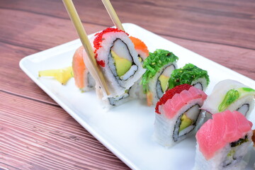 Traditional colorful suhi, cream cheese, salmon, caviar, rool sishi crunch, sesame seeds and sauce
