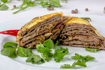 Beef sliced into thin slices baked under vegetables and cheese.