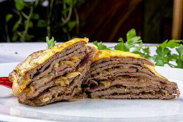 Beef sliced into thin slices baked under vegetables and cheese.