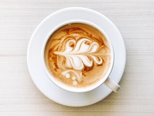 Top view of fresh cappuccino coffee in white ceramic cup closeup.
