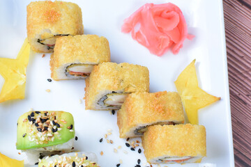 Traditional colorful suhi, cream cheese, salmon, caviar, rool sishi crunch, sesame seeds and sauce