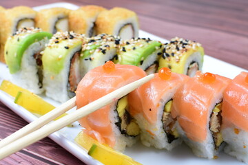Traditional colorful suhi, cream cheese, salmon, caviar, rool sishi crunch, sesame seeds and sauce