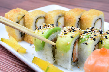 Traditional colorful suhi, cream cheese, salmon, caviar, rool sishi crunch, sesame seeds and sauce