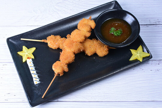 breaded fish chuzo, accompanied by red sauce