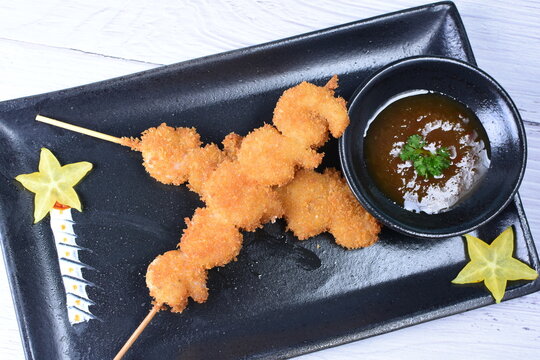 breaded fish chuzo, accompanied by red sauce