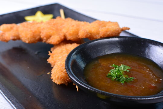 breaded fish chuzo, accompanied by red sauce