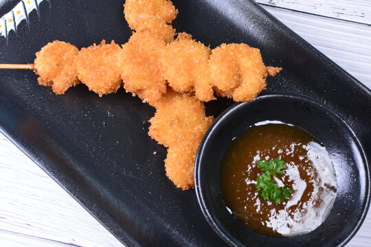 breaded fish chuzo, accompanied by red sauce