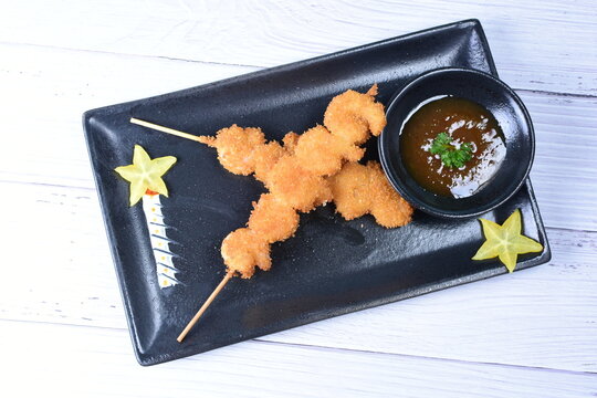 breaded fish chuzo, accompanied by red sauce