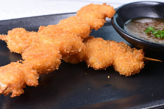 breaded fish chuzo, accompanied by red sauce