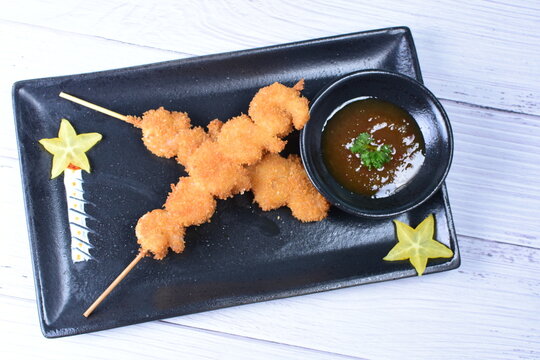 breaded fish chuzo, accompanied by red sauce
