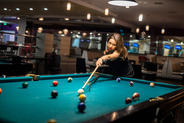 Happy caucasian woman wear casual cloth playing a game of billiards