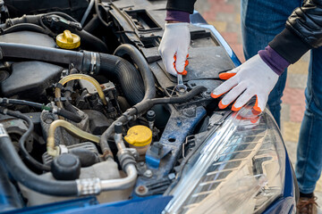 close up of mechanic hand using wrench to service car for repair or check engine