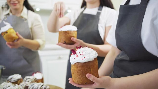 a women decorate icing, dried berries and flowers easter cakes.