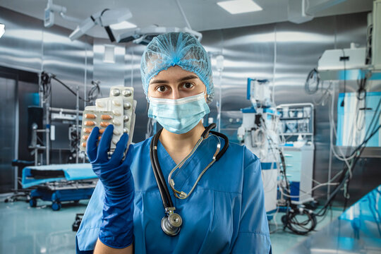 Female Doctor Wearing Blue Coat Uniform Holding Stethoscope And Pills In Hand