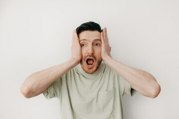 Handsome young man over grey wall shocked screaming with open cover mouth mock up, unexpected...