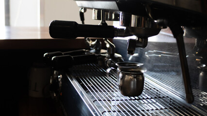 two metal cups in a coffee machine, inside a coffee shop in tulum, mexico.