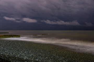 Night photo. Old ruined pier and sea with a full moon. Night Sea Surf.
