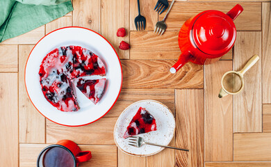 Cake with berry jelly with blueberries and raspberries on a wooden table