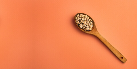 Black eyed peas in a wooden spoon on a black eyed peas