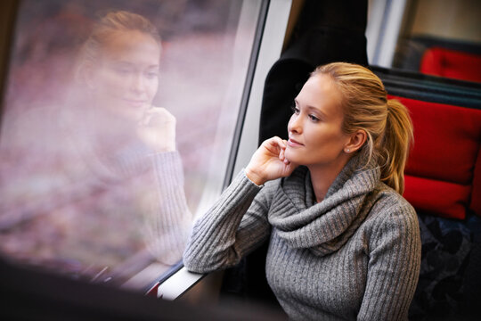 Taking in the streaking scenery. Cropped shot of an attractive young woman traveling by train.