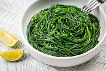 Sauteed agretti with lemon, italian food. Saltwort or salsola soda. Close up.