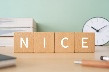 「NICE」と書かれた積み木ブロックが置かれたデスク