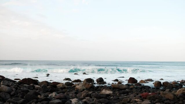 Serfers on a ocean wave on sunset, Atlantic Ocean