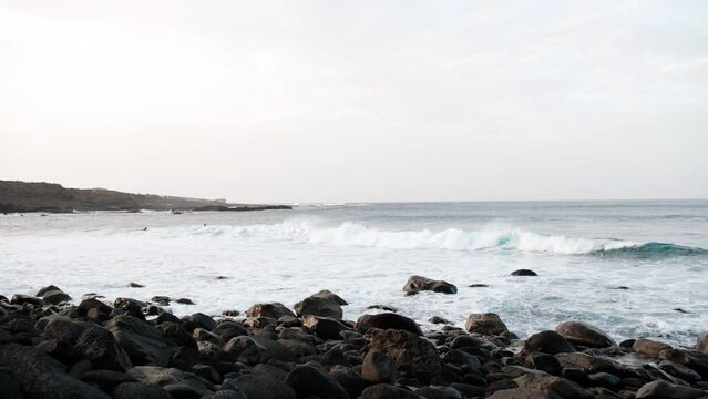 Serfers on a ocean wave on sunset, Atlantic Ocean