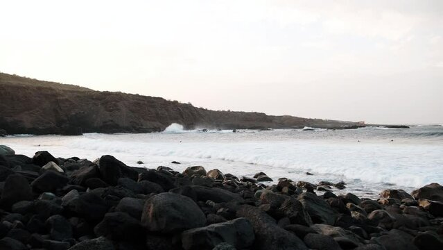 Serfers on a ocean wave on sunset, Atlantic Ocean