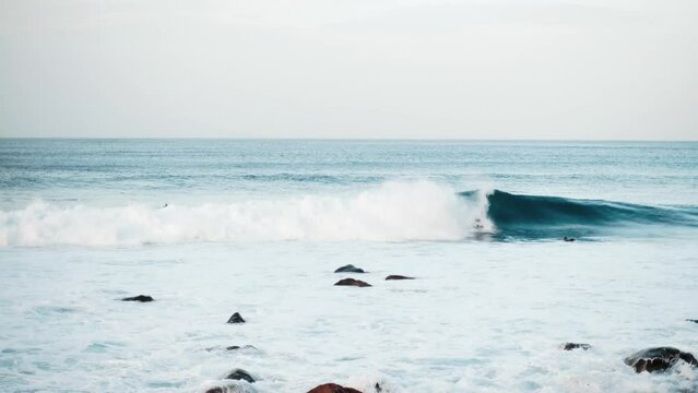 Serfers on a ocean wave on sunset, Atlantic Ocean