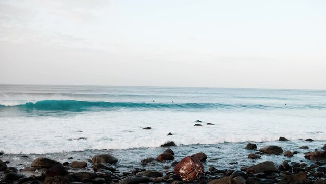 Serfers on a ocean wave on sunset, Atlantic Ocean