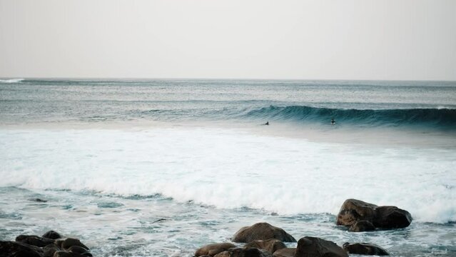 Serfers on a ocean wave on sunset, Atlantic Ocean