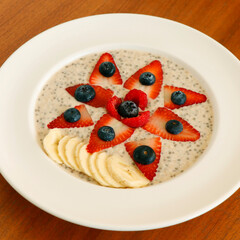 oat porridge chia seed meal with fresh berries and banana in a bowl