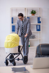 Young male employee looking after new born at workplace