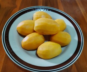 Sweet marian plum peeled in plate on wooden background