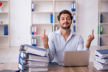 Young male employee unhappy with excessive work in the office