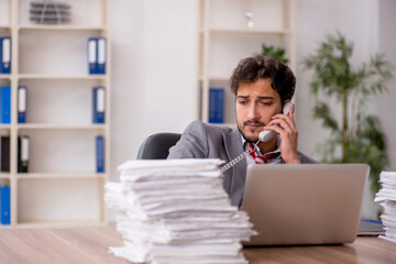 Young male employee unhappy with excessive work in the office