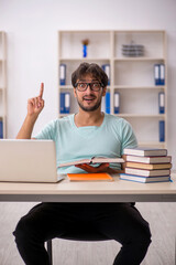 Young male student preparing for exams in the classroom