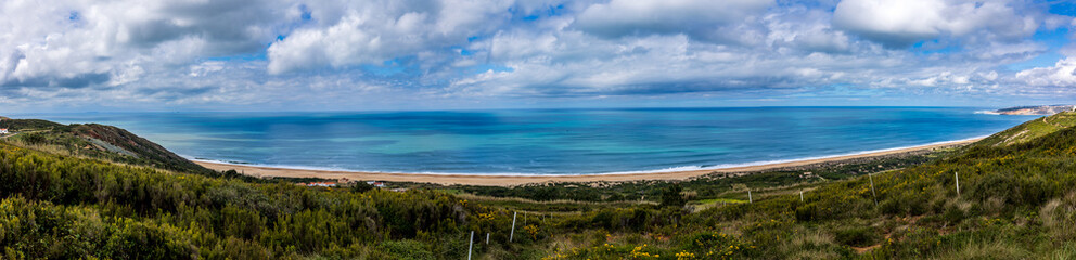 Panoramic view of the Beautiful beach of Salgados with the village of Nazare in the background, Portugal. Beautiful beach with turquoise waters in a cloudy day