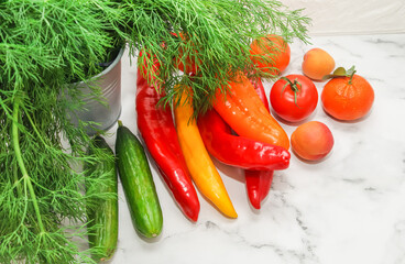 Seasonal vegetables and tropical fruits on a marble table near a white brick wall.
