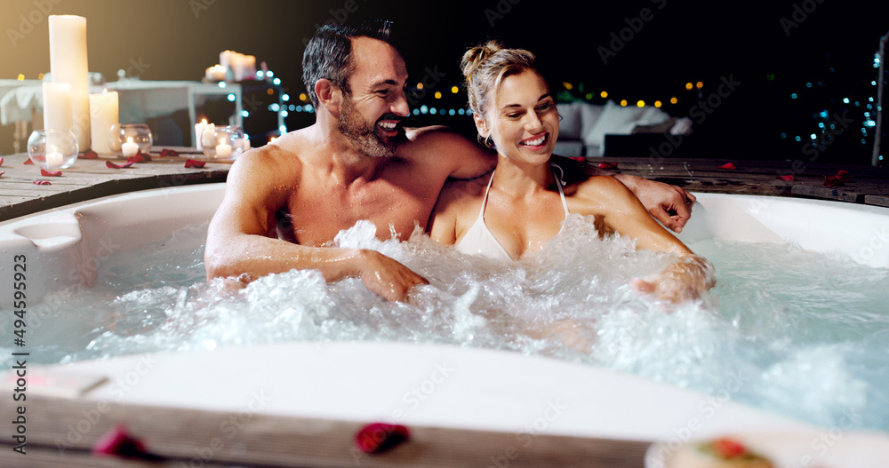 Sticker Celebrating our love the best way we know how. Shot of an affectionate mature couple relaxing in a hot tub together at night.