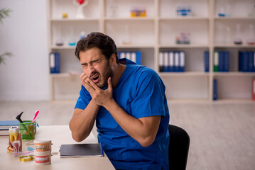 Young male dentist working in the clinic