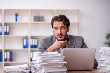 Young male employee and too much work in the office