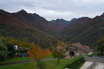 Houses in Picos de Europa nationalo park with mountains on the background during Autumn fall, in Spain