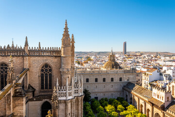 View from the Giralda Tower out over the courtyard of the Seville Cathedral with the city and Sevilla Tower Skyscraper in view. - obrazy, fototapety, plakaty