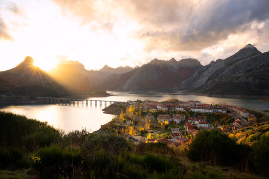 Riano cityscape with sun flare in the mountain range during Autumn in Picos de Europa national park, Spain