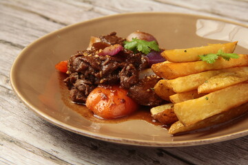 Freshly cooked beef briskets in garlic sauce served with french fries