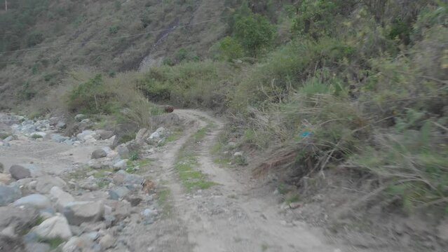 three men standing on the edge of Mountain dirt road vehicle tracks leading out to riverbed opening boulders rocks sand i valley Kabayan Benguet Philippines fast reverse revealing people aerial