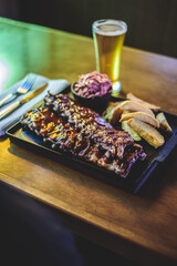 pork ribs board with barbecue, potatoes and beer
