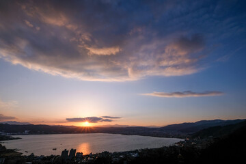 Fototapeta na wymiar 長野県諏訪市立石公園からの夕日と諏訪湖